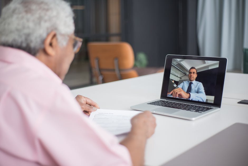 Senior discussing business on a video call with a consultant on a laptop