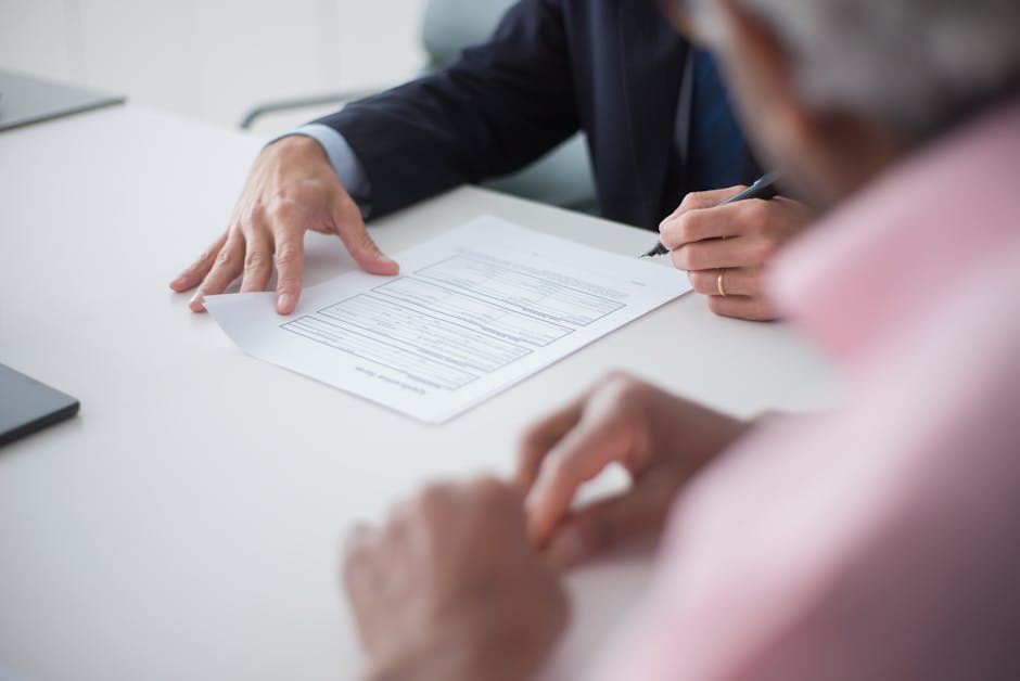 Two professionals engaging in a business meeting, signing documents for a consulting agreement